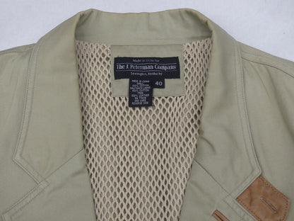 Close-up of the collar and inner neck of a vintage olive green jacket by The 1. Peterman Company, showing a beige mesh lining and a black brand label.