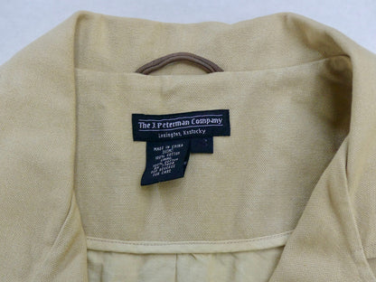 Close-up of the inside collar of a light beige woven garment, showing a black fabric label that reads 'The J Peterman Company' with 'Lexington, Kentucky' underneath.