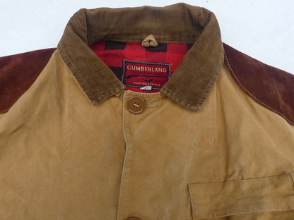 A close-up of a Cumberland work jacket showing the tan corduroy collar, brown suede shoulder panels, and red plaid inner lining.